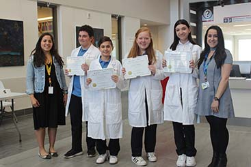 Les étudiants de l’école secondaire Lester B. Pearson tiennent fièrement dans leurs mains les Certificats de mérite remis par leurs mentors de l’IR-CUSM : Paulina Garcia de Alba Graue et Christina Mastromonaco, pour leur projet en ophtalmologie dans le laboratoire du Dr Burnier.