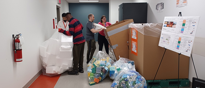 Les bacs sont pleins! Les ambassadeurs du recyclage issus du Programme en maladies infectieuses et immunité en santé mondiale (programme MIISM) vident leurs bacs de matières recyclables afin de se préparer pour la collecte. De gauche à droite, Ali Salim (Services techniques), Louis Cyr et Angela Jean Brewer (tous deux du programme MIISM).