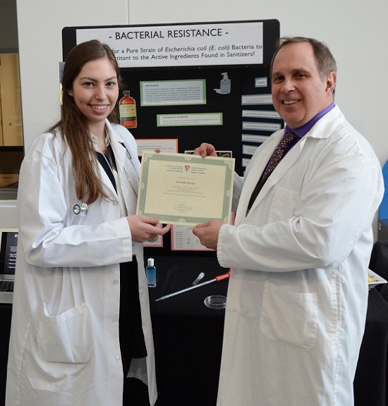 Le Dr Martin Olivier présente un certificat de participation à la future scientifique Isabelle Steber, du Lower Canada College.