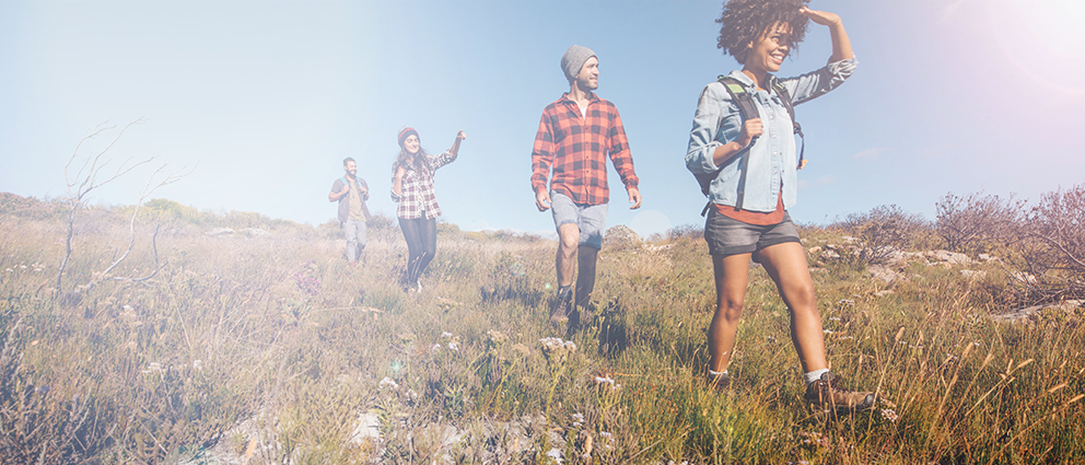 Young people look ahead while hiking in a field